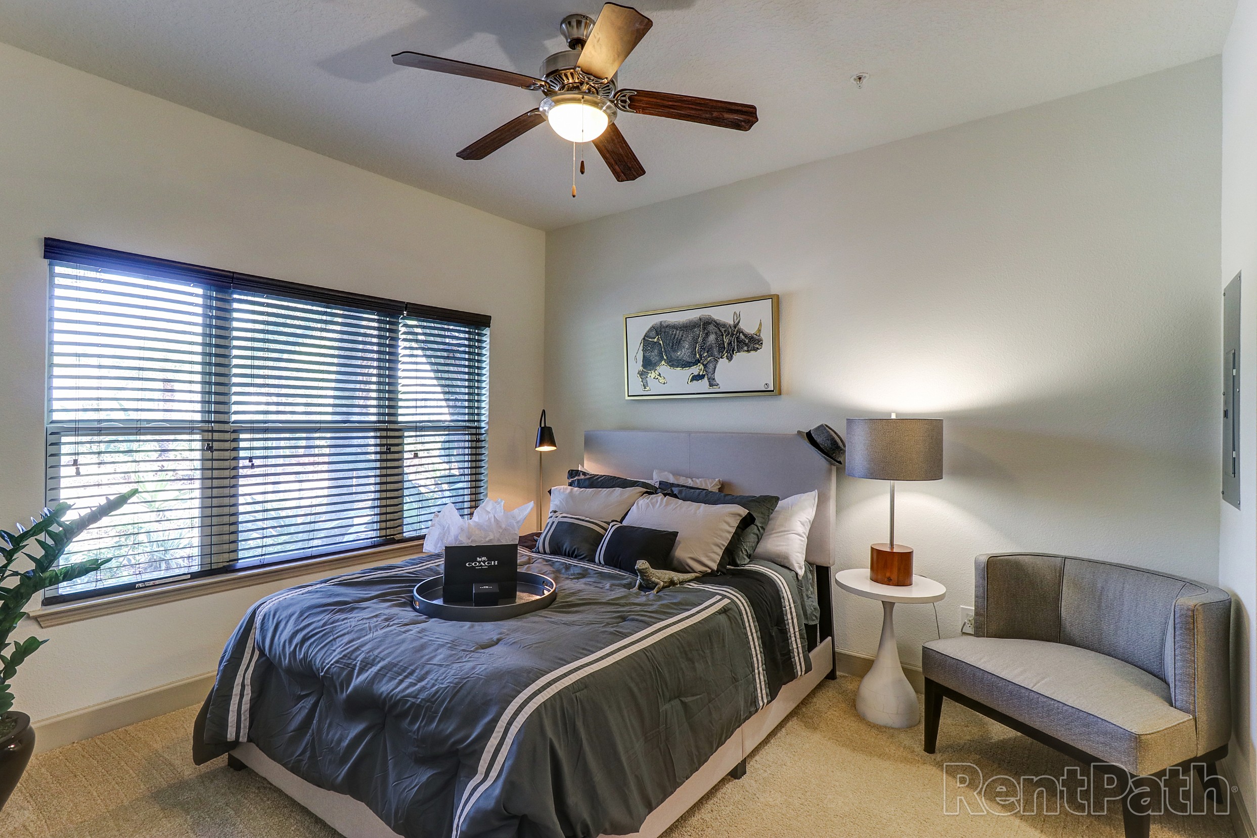 Model bedroom with ceiling fan and large windows at Astoria at Celebration1