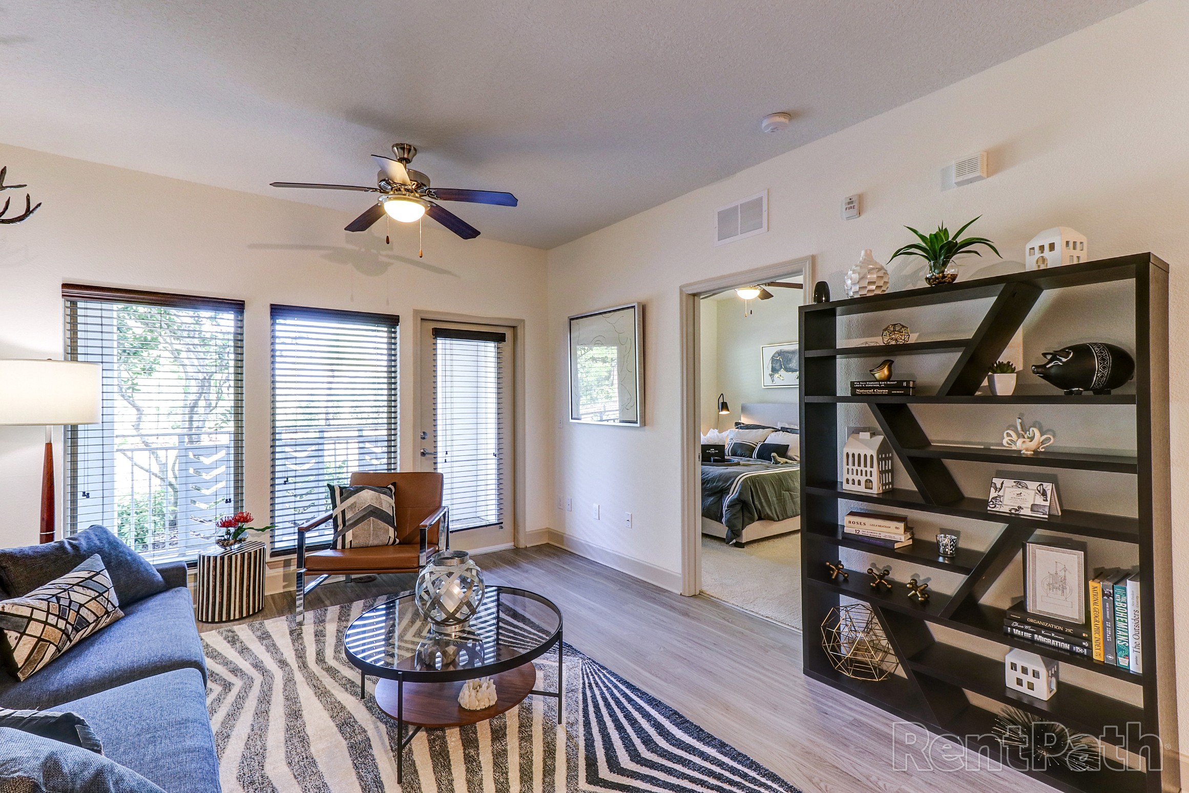 Model living room with luxury vinyl plank flooring and ceiling fan